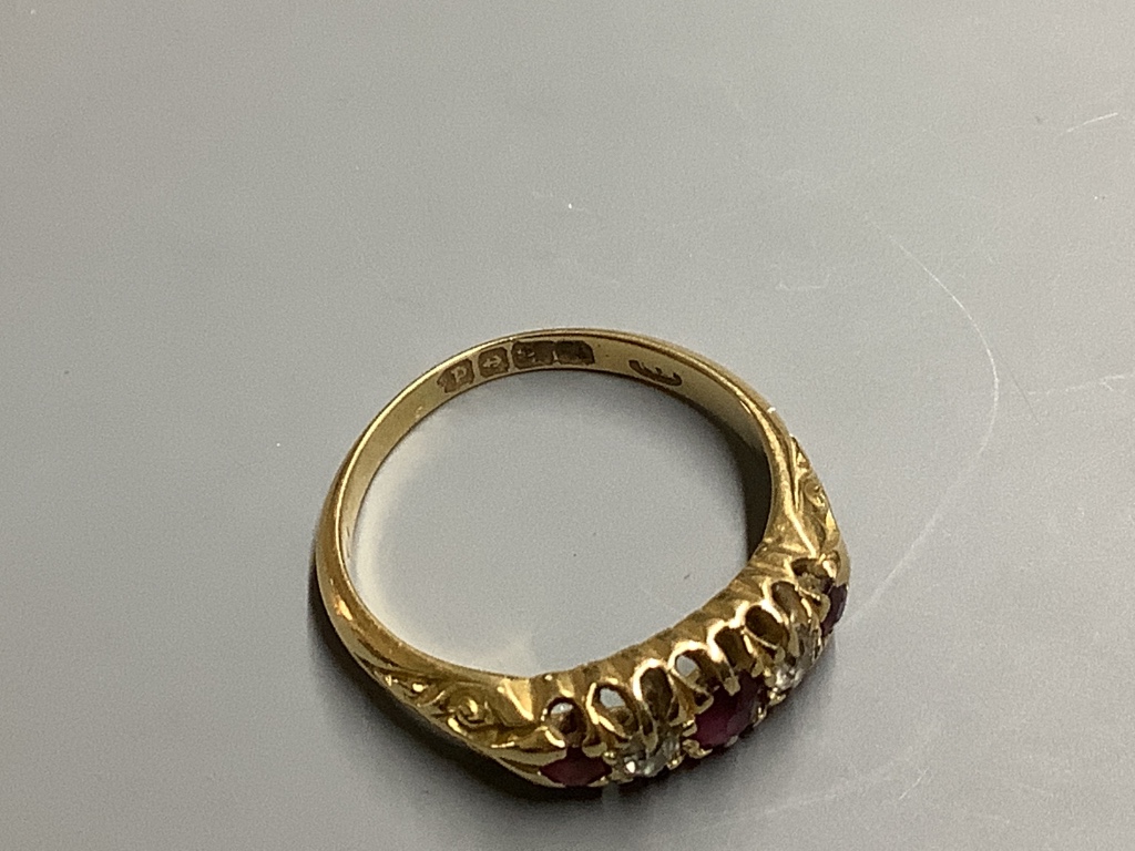 An Edwardian 18ct gold, three stone ruby and two stone diamond set half hoop ring